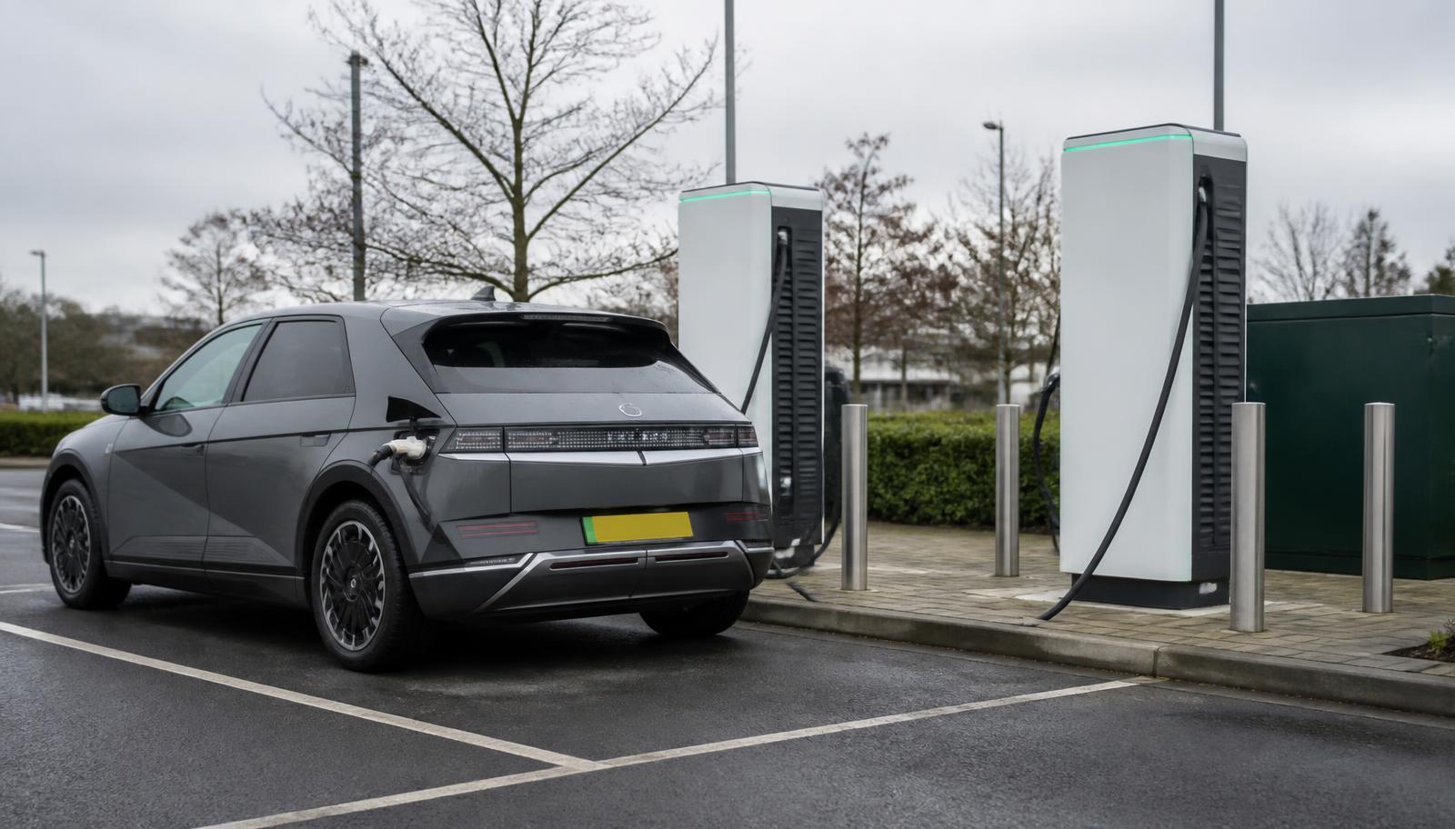 Electric car charging at a public rapid charging station in a UK car park